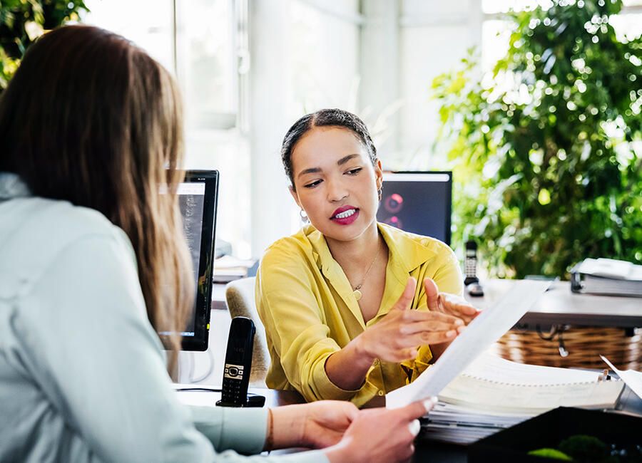 two people talking holding paper
