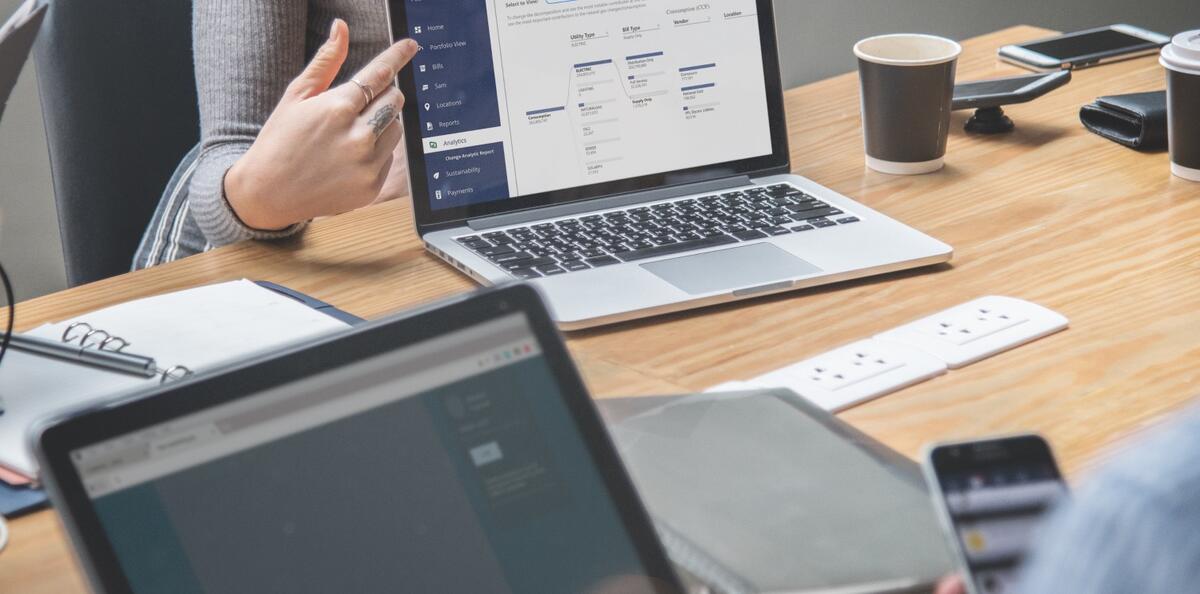 Person pointing to laptop screen during a meeting