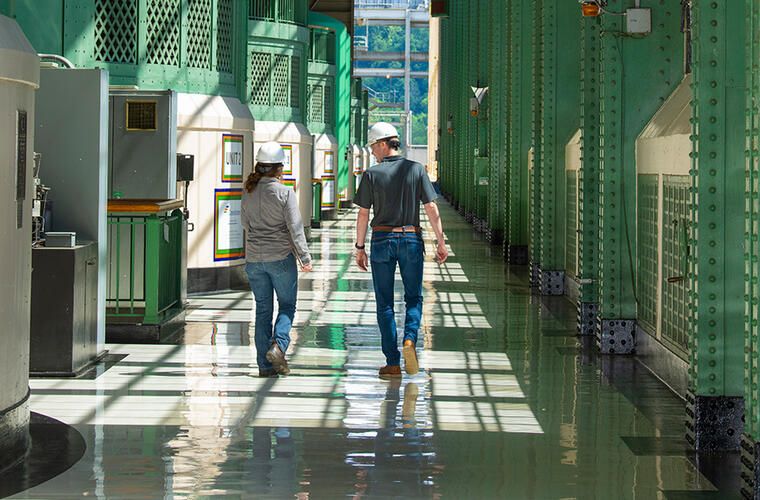 Two people walking green walls