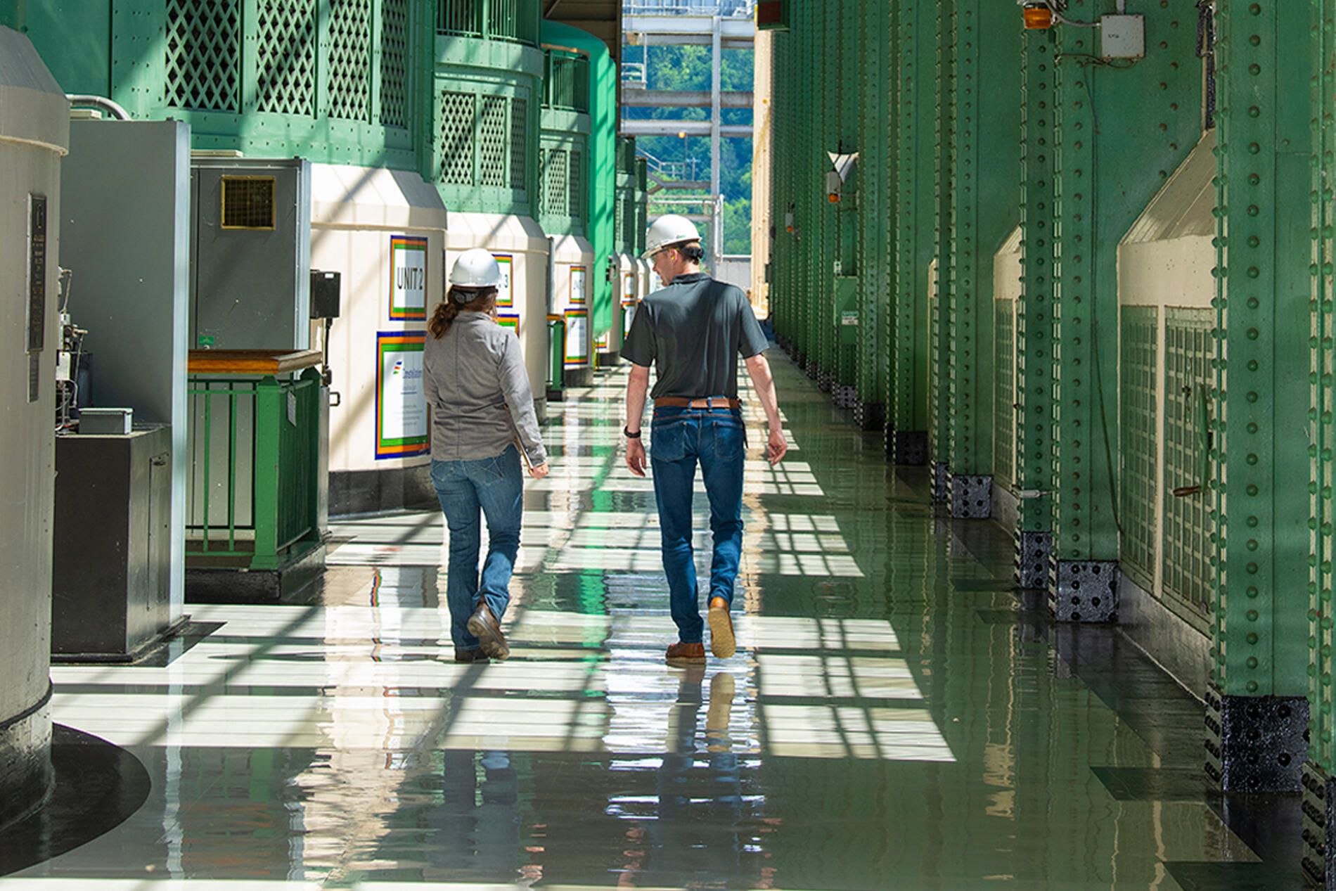 Two people walking green walls